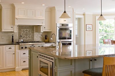 traditional kitchen with marble countertops and microwave in island.