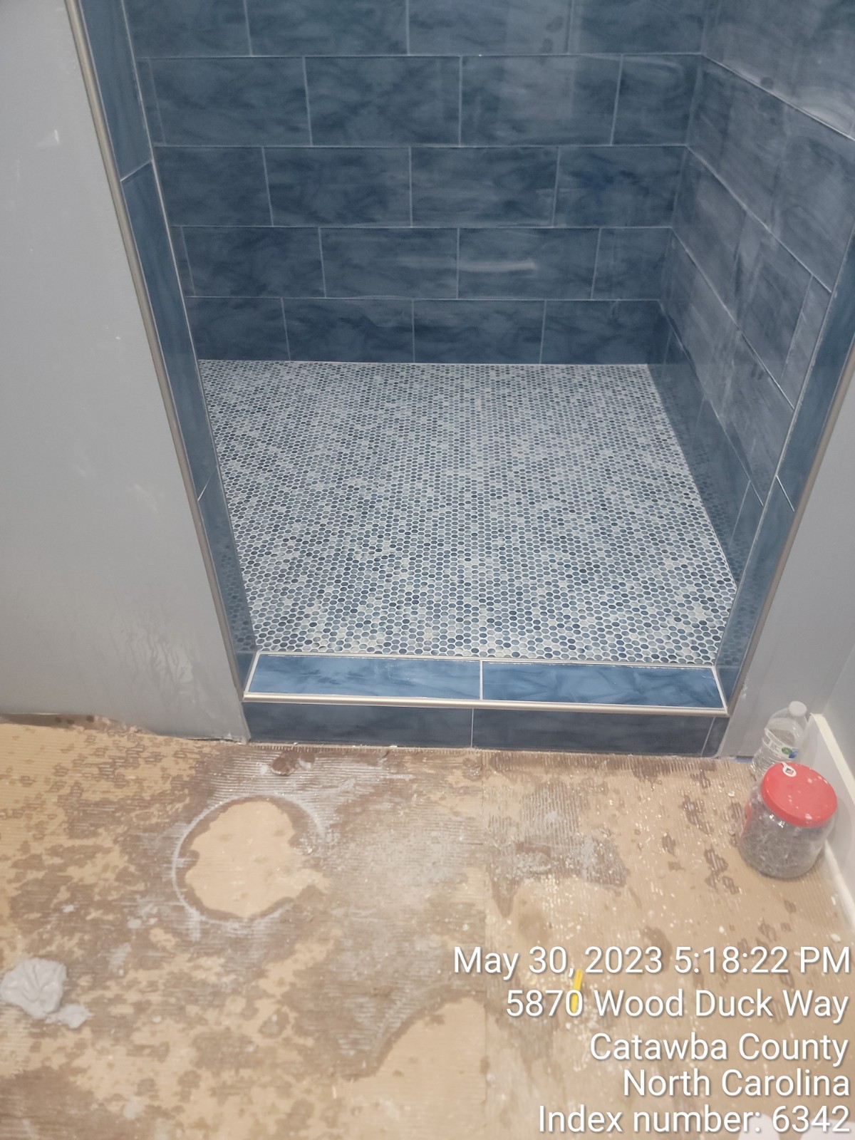 View of shower with blue and white tiles.