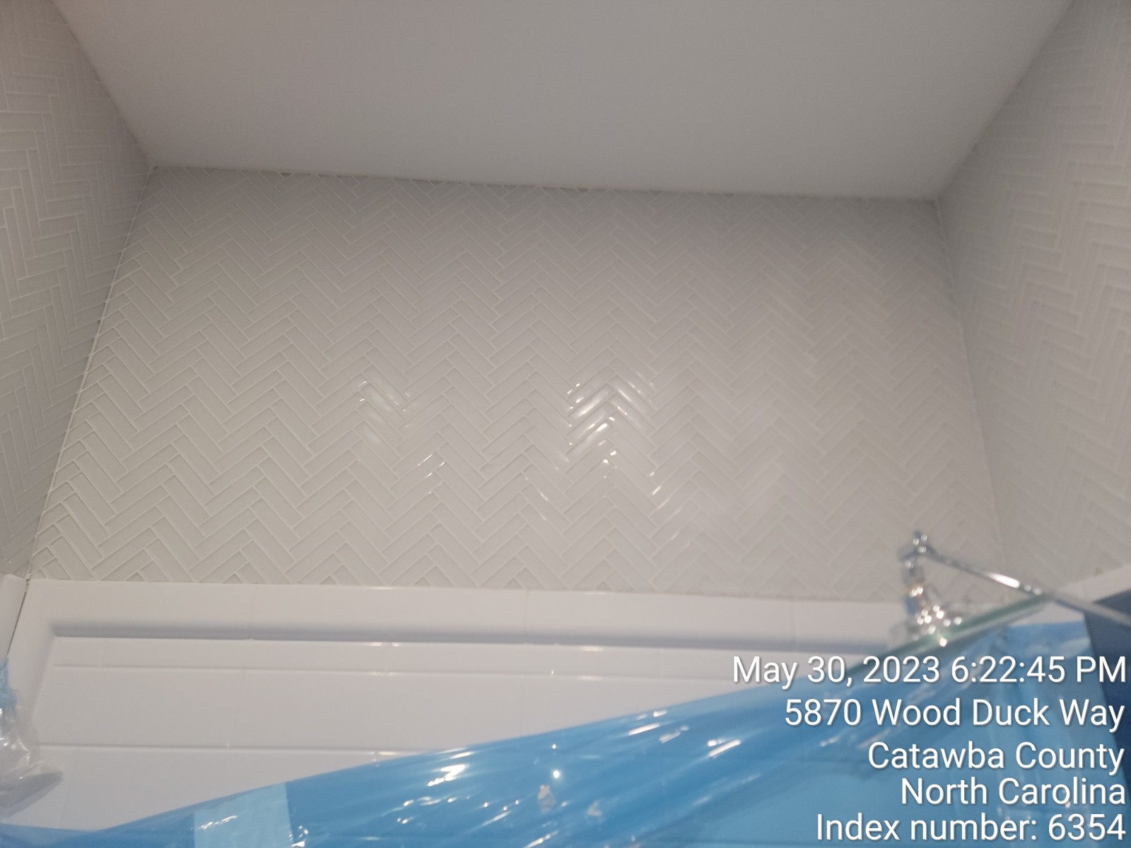 view of shower with white tiles.